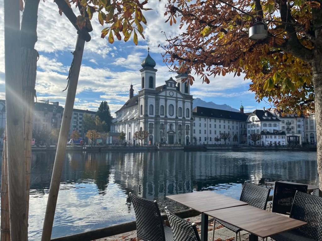 view over river in Lucerne to the Jesuit chapel, framed by fall leaves