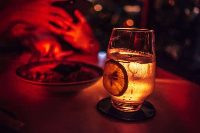 cocktail on a table in a dark bar environment with red lighting 