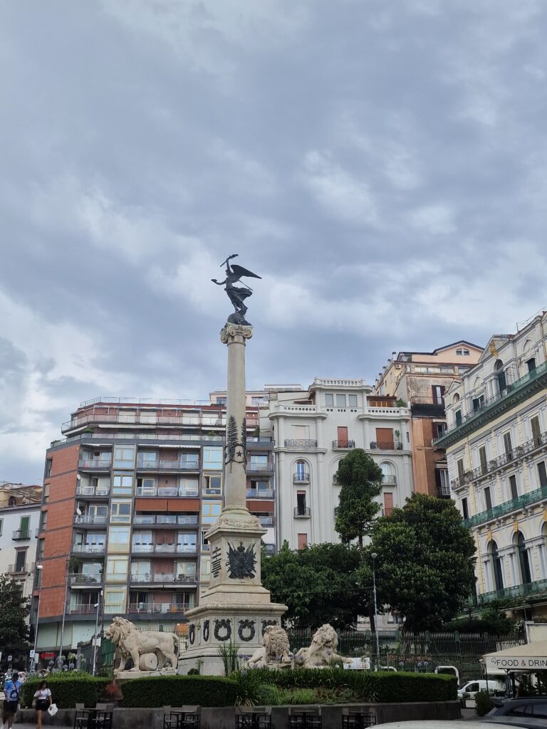 View of monument of Naples against buildings in the background