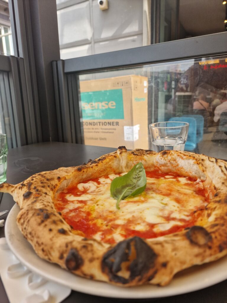 Margharita pizza on a plate – fluffy crust, red tomato sauce, cheese and a garnish of basil