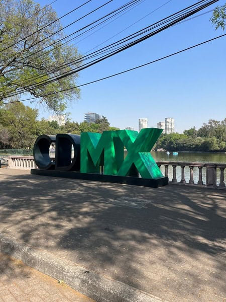 life size block lettering in a park reading CDMX in black and green letters