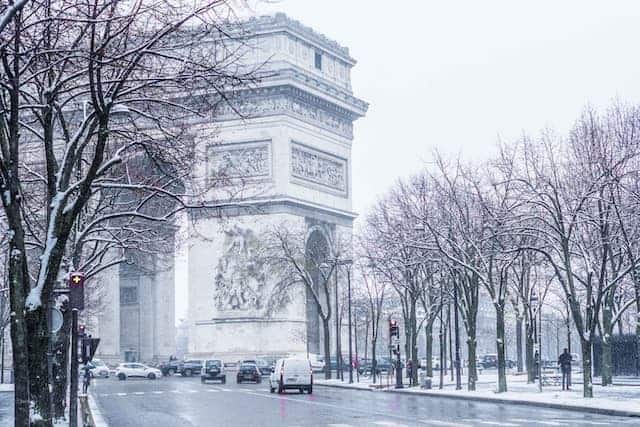 does it snow in Paris? yes, view of arc de triomphe Paris in the snow