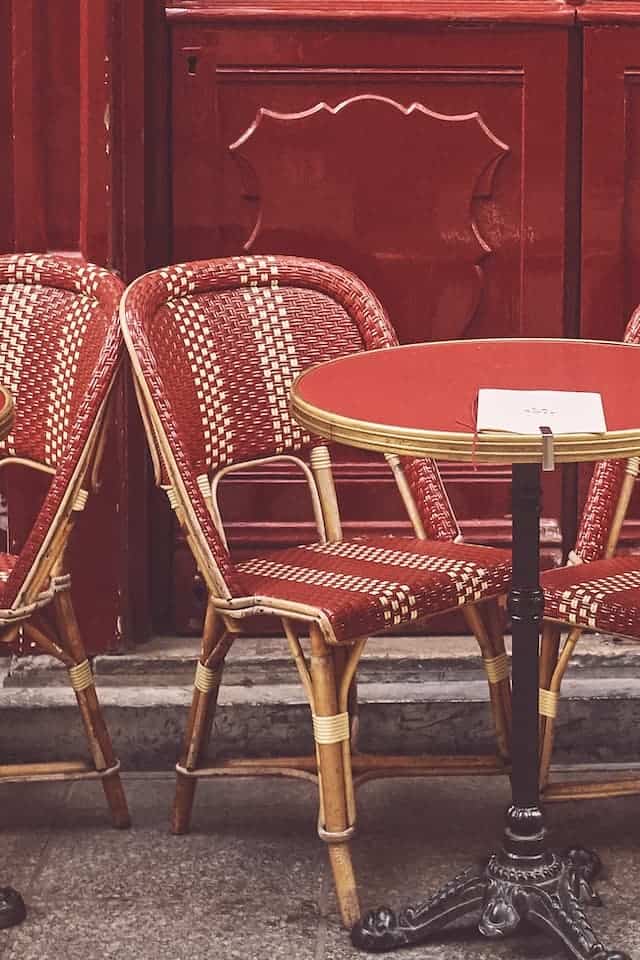 non touristy things to do in Paris, food edition. red table and red chair outdoors 