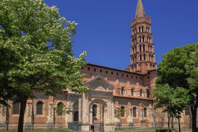 a pink-bricked building in Toulouse with a turret