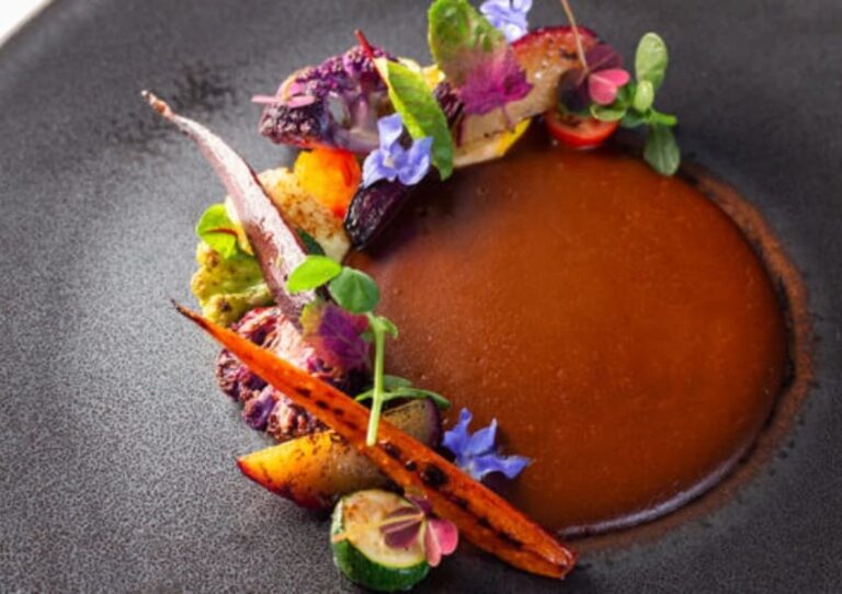 A plated dish surrounded by colorful garnish at Mexico City restaurant, quintonil