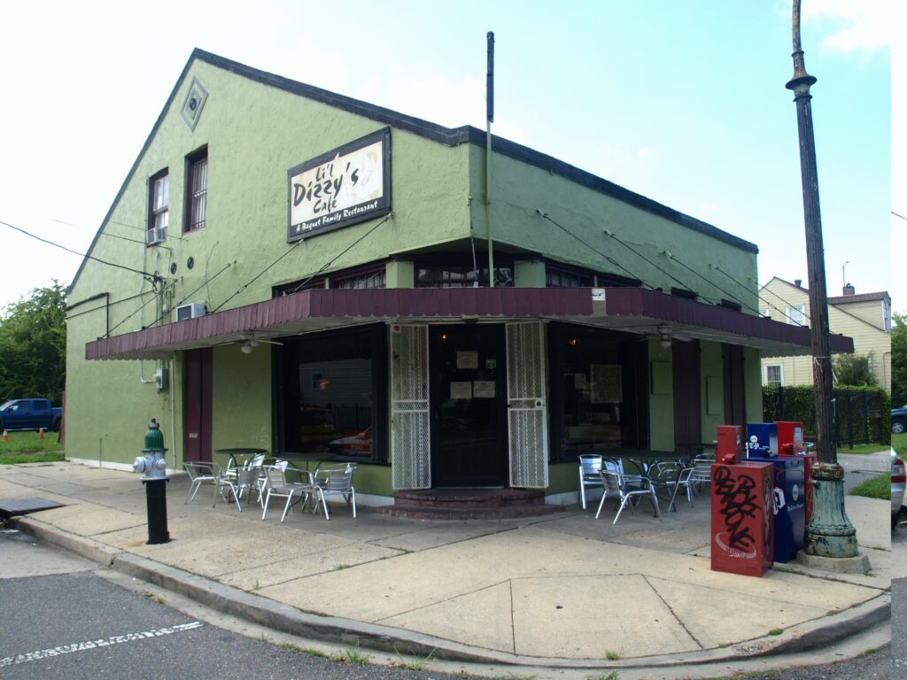 green building with pointed ceiling like a house with a sign saying Lil Dizzy's on it