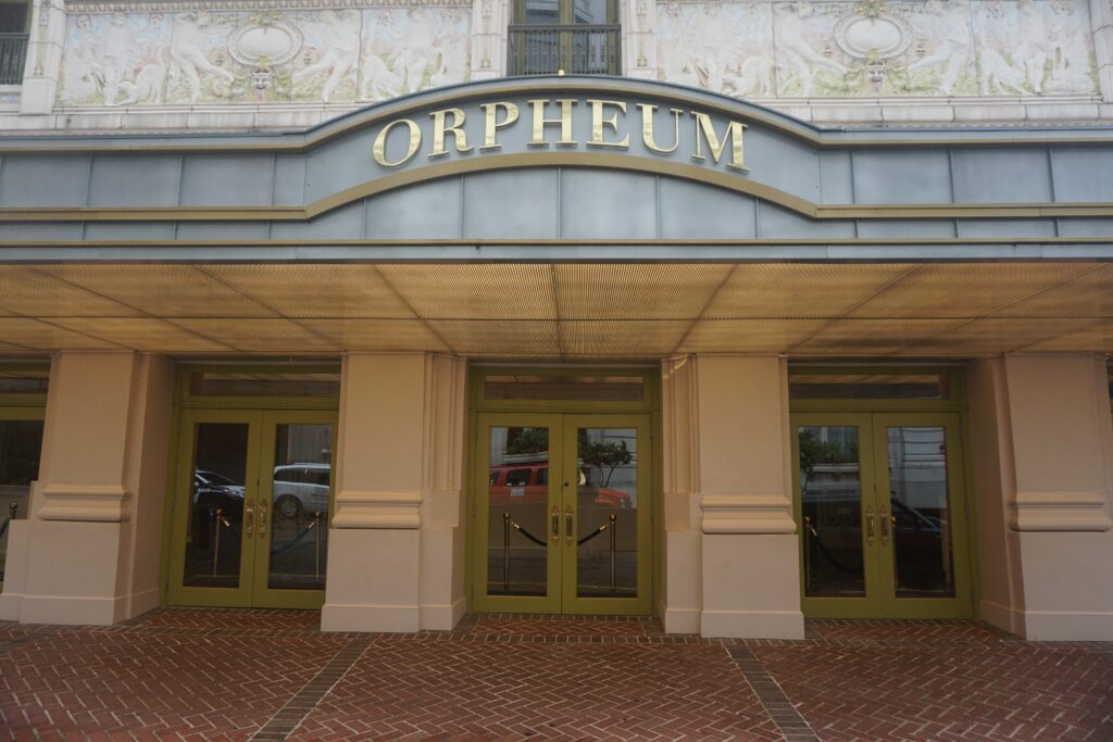 Exterior of Orpheum Theater in New Orleans in winter, with Orpheum written in gold letters above the entrance