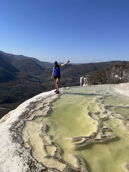 woman at the rim of a pool at Hierve el Agua with mountains in the background