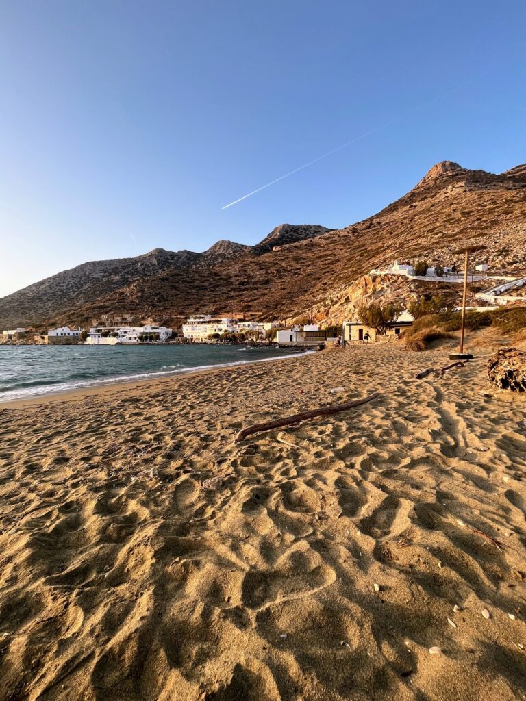 sandy beach with mountain in background and sea on the left