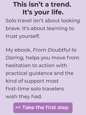 Purple-toned graphic with motivational text about solo travel. It reads: “This isn’t a trend. It’s your life. Solo travel isn’t about looking brave. It’s about learning to trust yourself.” Below that, it promotes an ebook titled From Doubtful to Daring, which offers guidance and support for first-time solo travelers. A purple button at the bottom says, “>> Take the first step.”